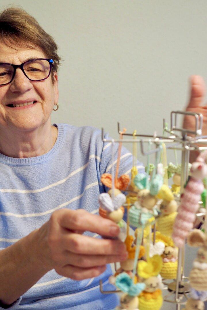 Ein Foto von Ottilie die grinsend ihre Würmchen an einem Halter dreht.