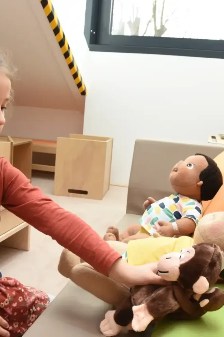 kind spielt mit einem stoffaffen