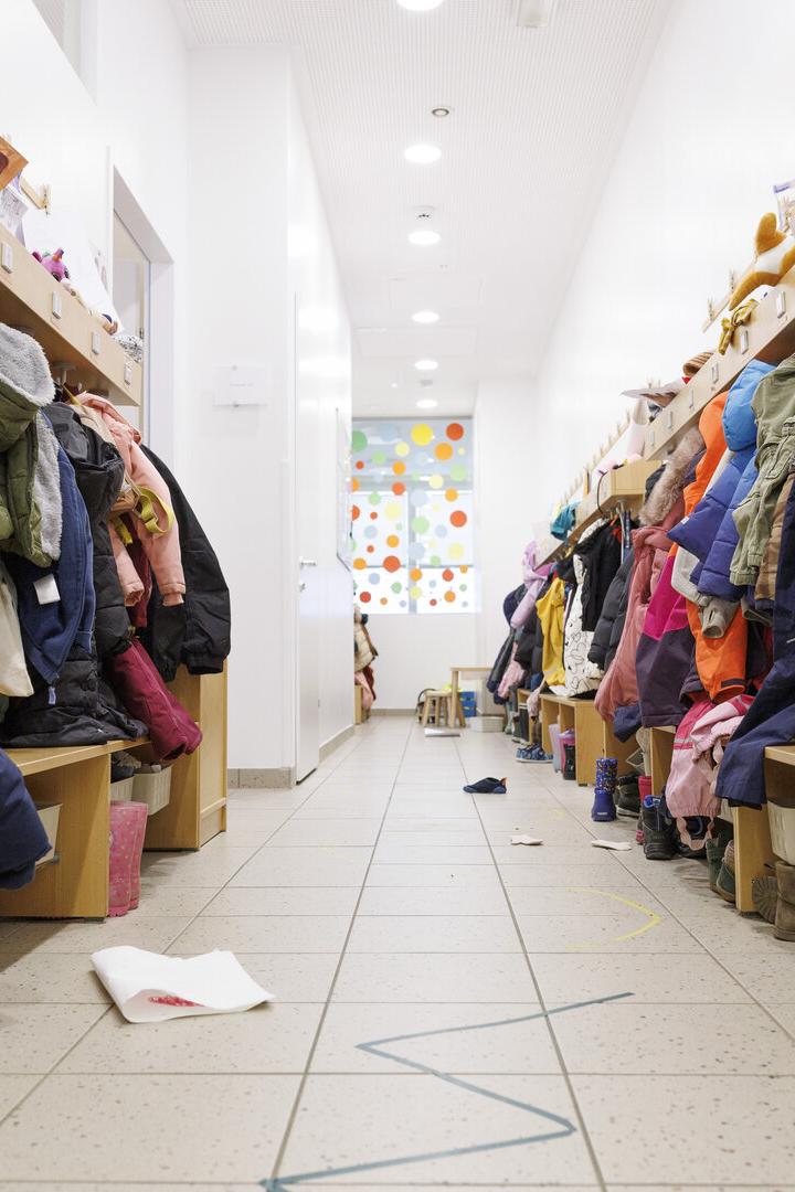 Eine Garderobe mit Jacken in einem Kindergarten.