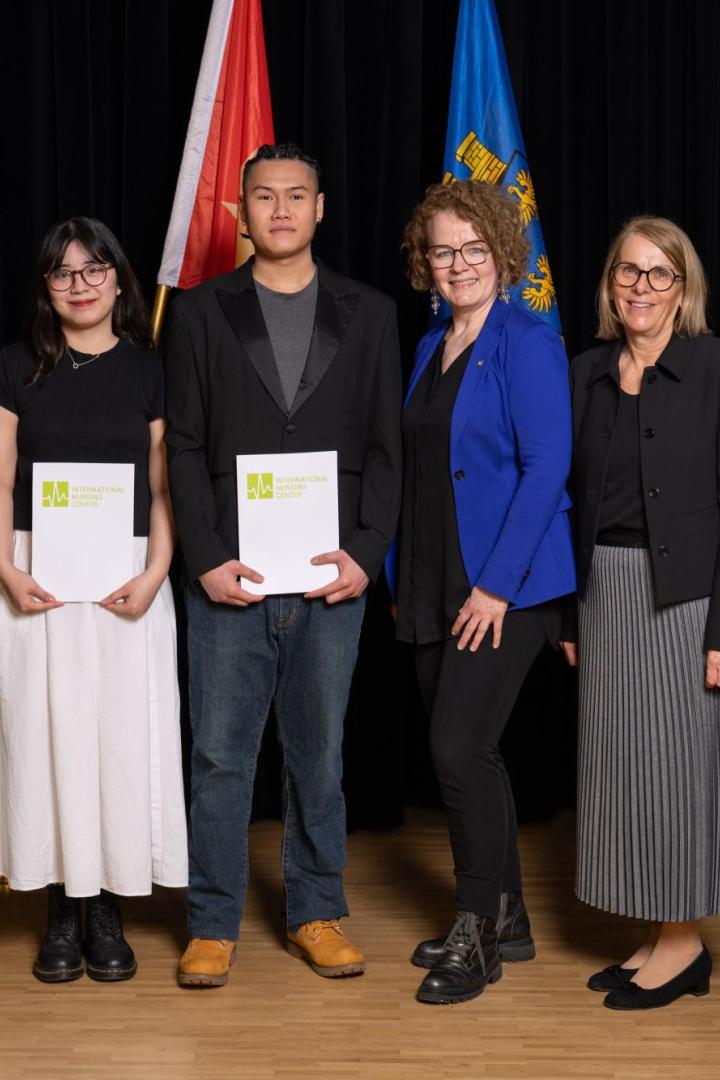Mehrere Personen stehen vor einer Wand vor der auch die Flaggen von Vietnam, Österreich, Niederösterreich und der EU platziert sind und lächeln in die Kamera.