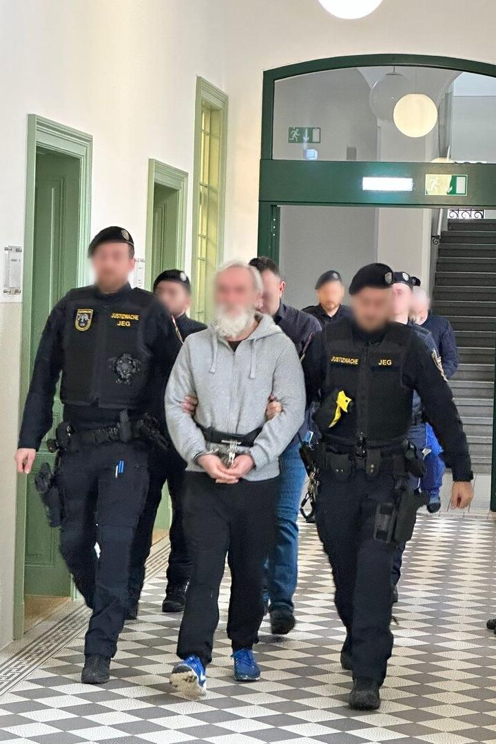 Justizwachebeamte führen Angeklagte vor