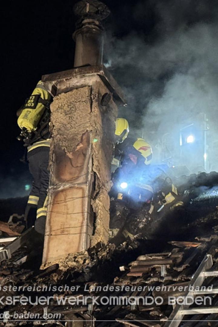Der gelöschte Dachstuhl, mehrere Feuerwehrleute sind auf dem dampfenden Dach zu sehen.