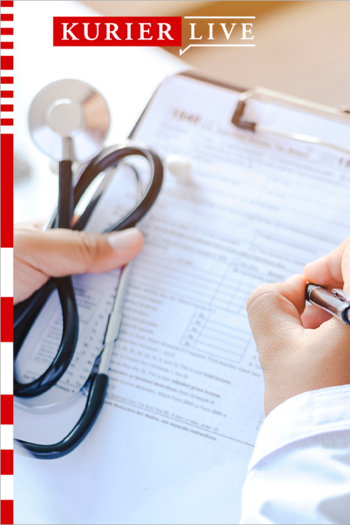 man sieht Gesundheitspersonal mit einem Klemmbrett in der Hand und eine Person, die gegenüber sitzt 