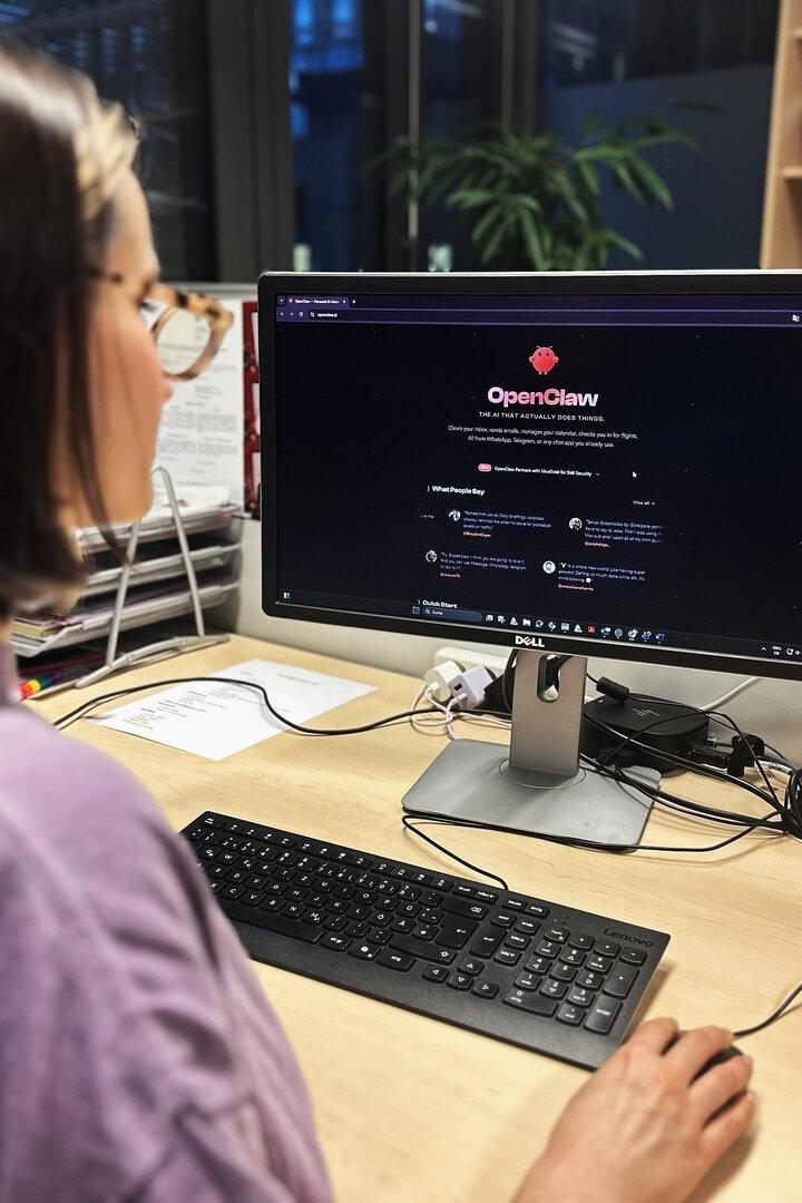 Eine Person sitzt vor einem Computer mit der OpenClaw-Webseite auf dem Bildschirm.
