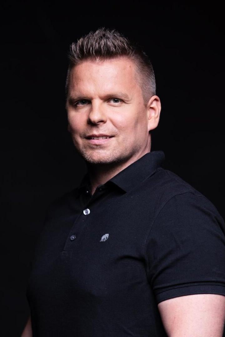 Ein Mann vor dunklem Hintergrund