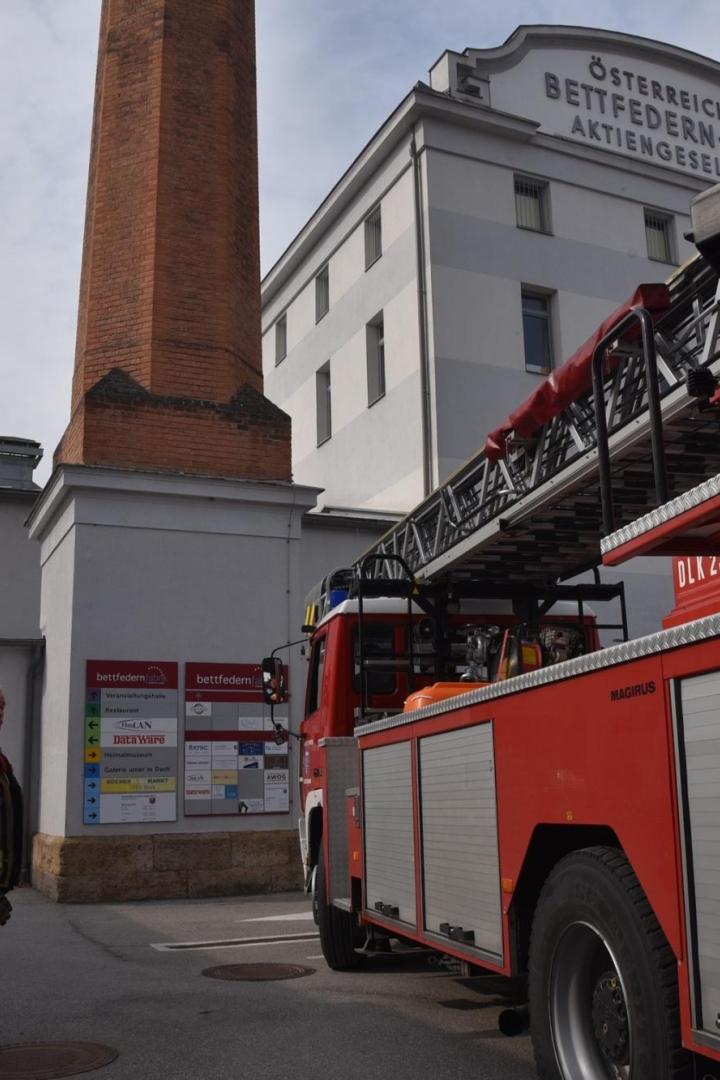 Ein Feuerwehrauto vor einem Fabriksgebäude