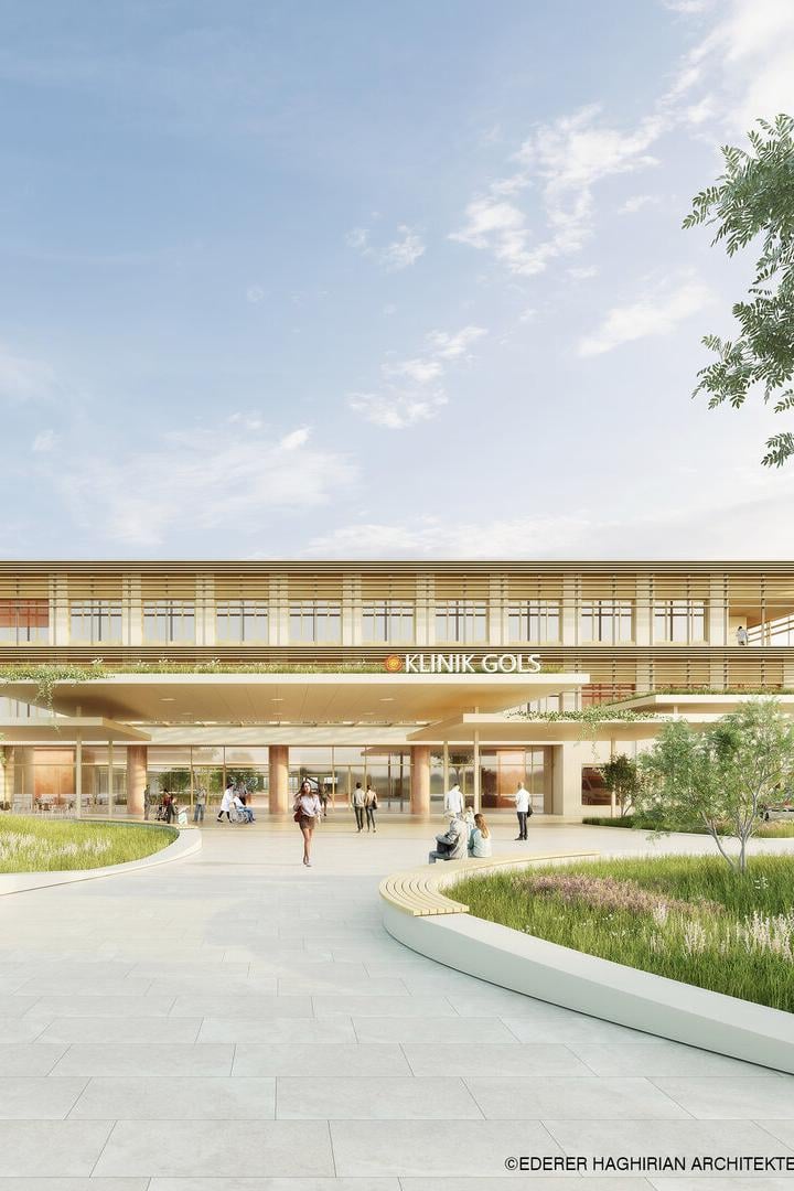 Modernes Klinikgebäude mit großen Glasfronten, umgeben von Grünflächen, Menschen sitzen und gehen auf dem Vorplatz.