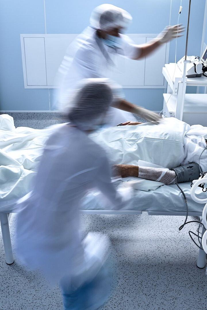 unrecognizable doctors nurses save a patient from death lying on bed in hospital