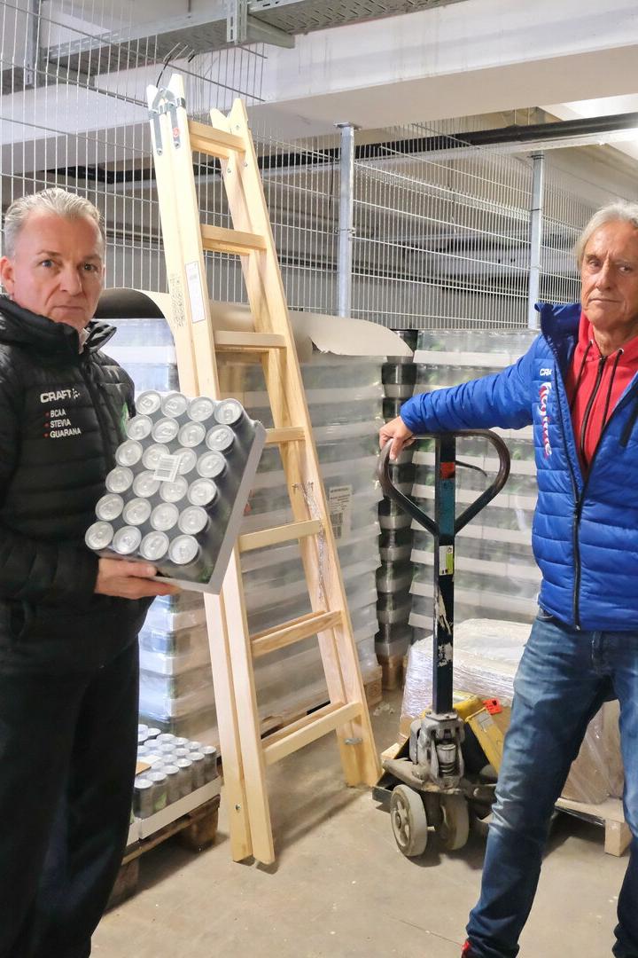 Zwei Männer stehen in einer Lagerhalle