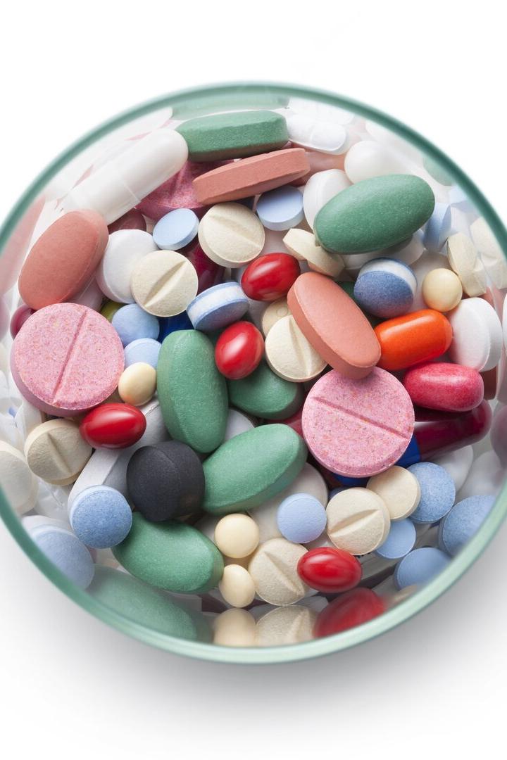 Ein Glas ist gefüllt mit einer Vielzahl von bunten Pillen und Tabletten.