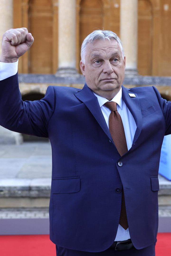 Ein Mann im blauen Anzug hebt seine Muskelarme