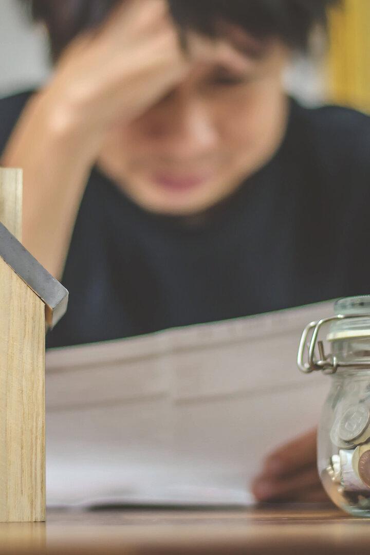 Ein junger Mensch checkt die aktuellen Kosten für die Wohnung, 