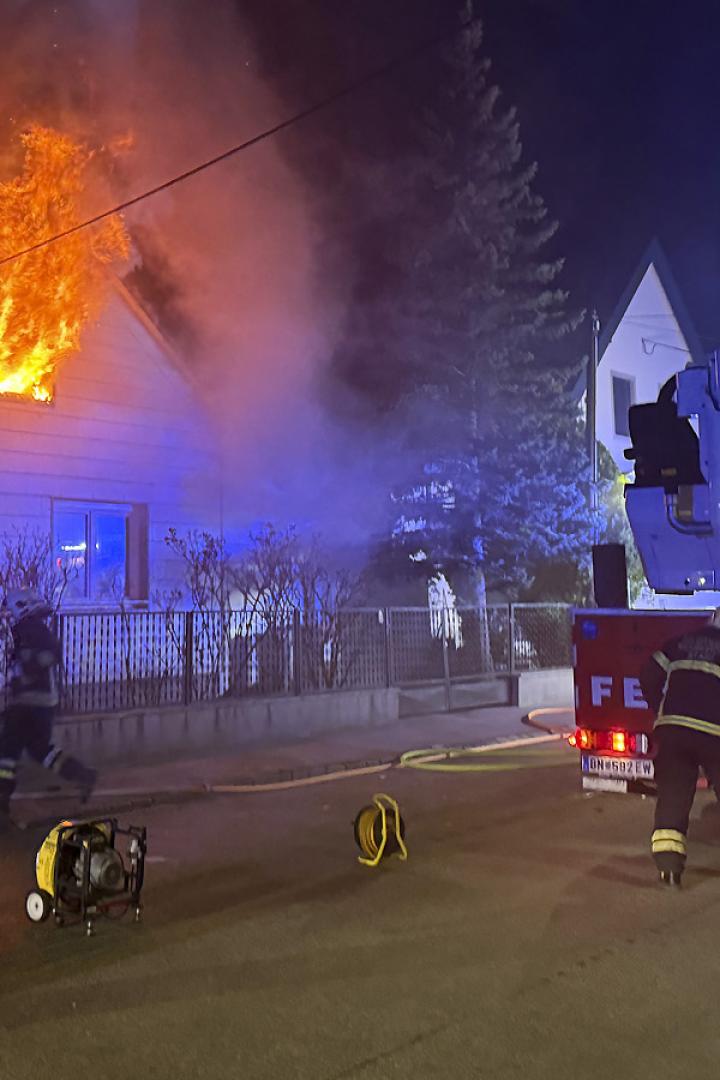 Eine Aufnahme der Feuerwehr vor dem Einfamilienhaus, aus dessen Fenster Flammen schlagen.