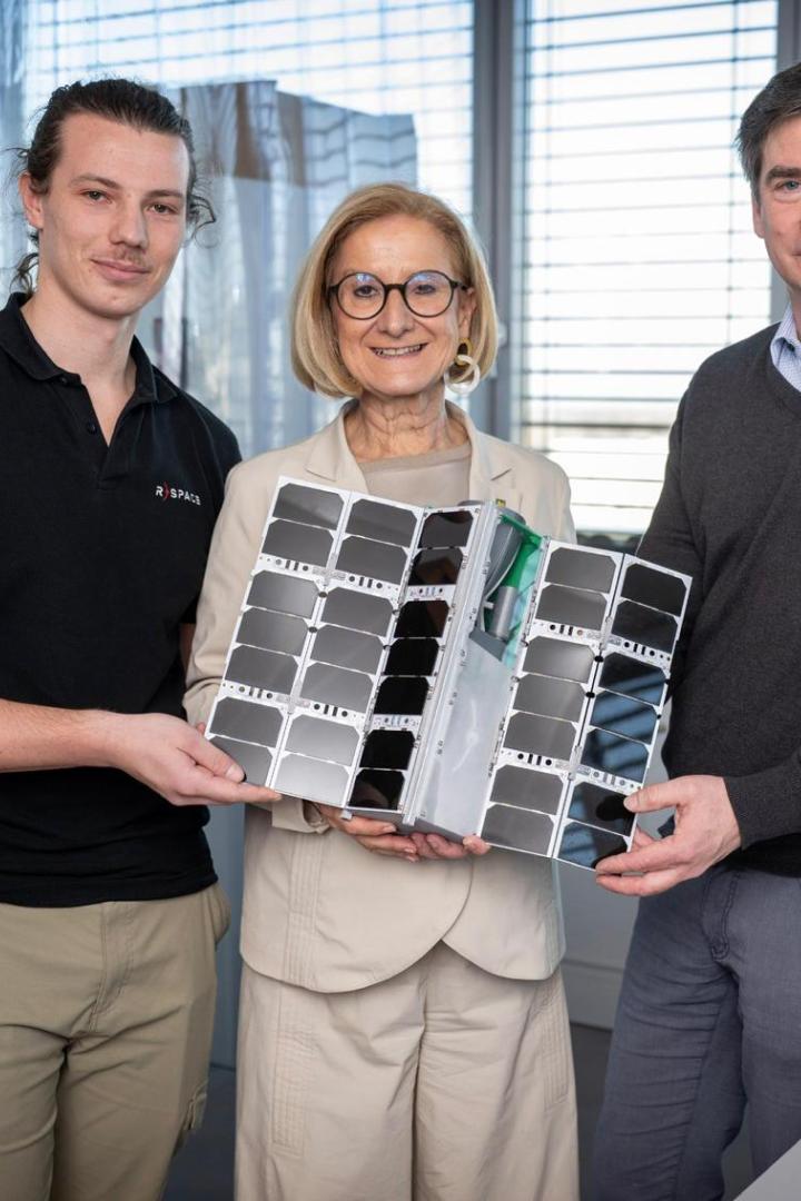 Zwei Männer und eine Frau blicken in die Kamera