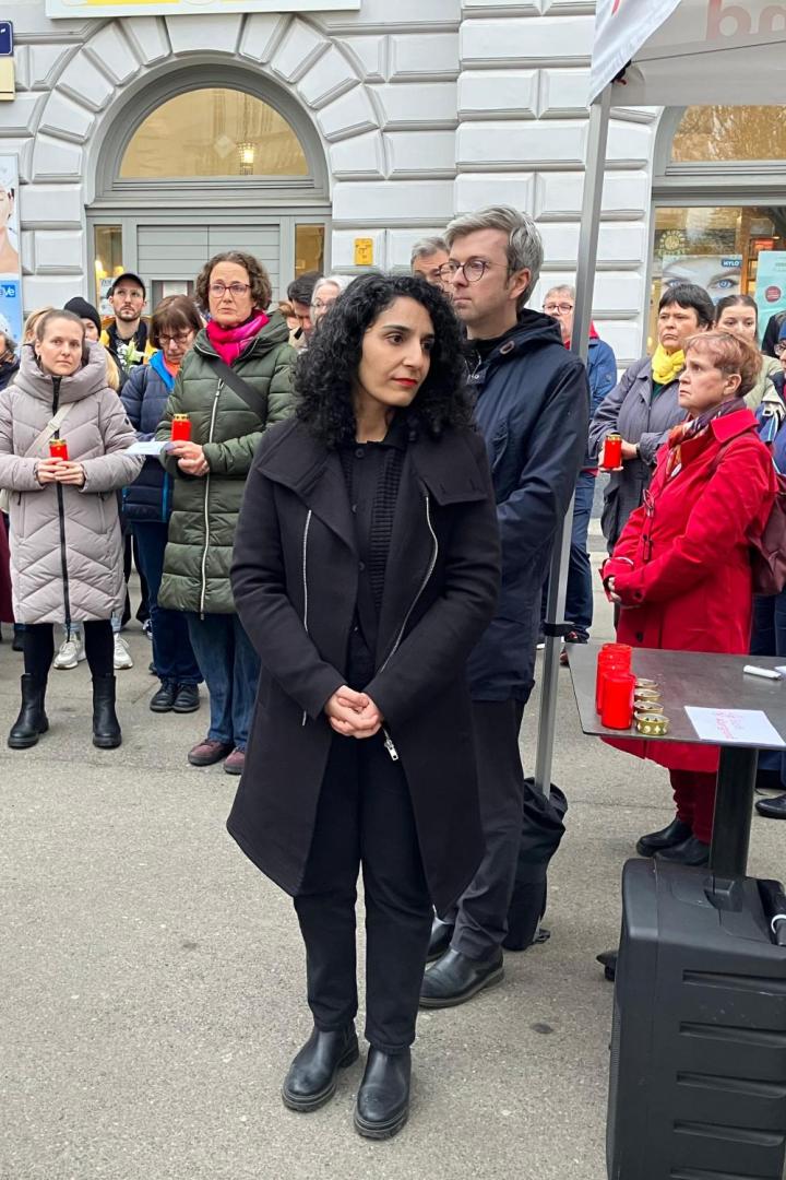 Menschen versammeln sich mit Kerzen zu einer Gedenkveranstaltung am Bauernfeldplatz.