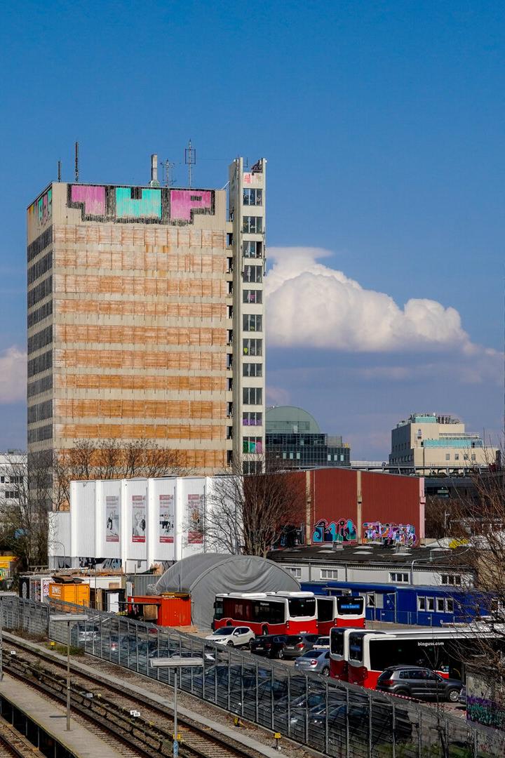 Im Vordergrund verlaufen Bahngleise, dahinter stehen Gebäude, darunter ehemalige APA-Haus.