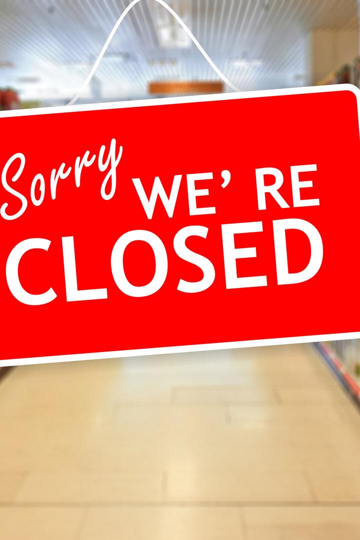 Ein rotes Schild mit der Aufschrift "Sorry, we're closed" hängt in einem Supermarktgang.