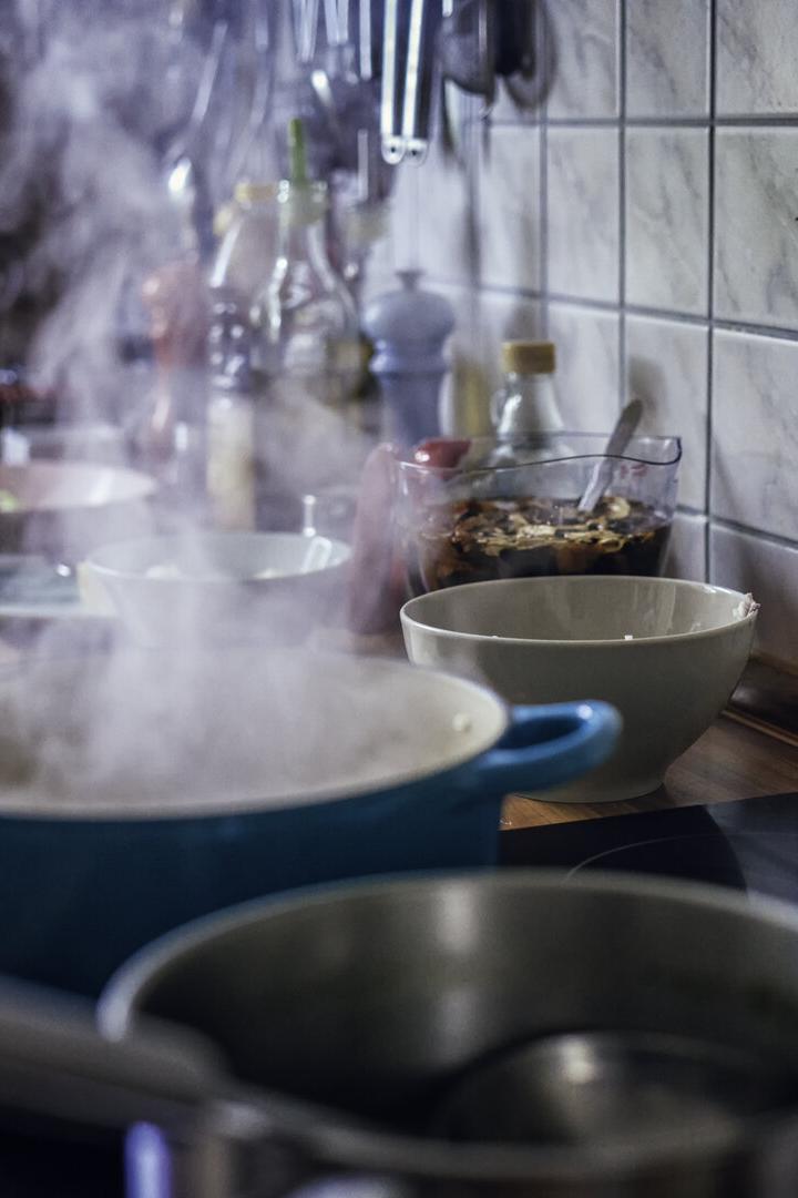 Auf dem Herd blubbert es in mehreren Töpfen und Wasserdampf steigt auf
