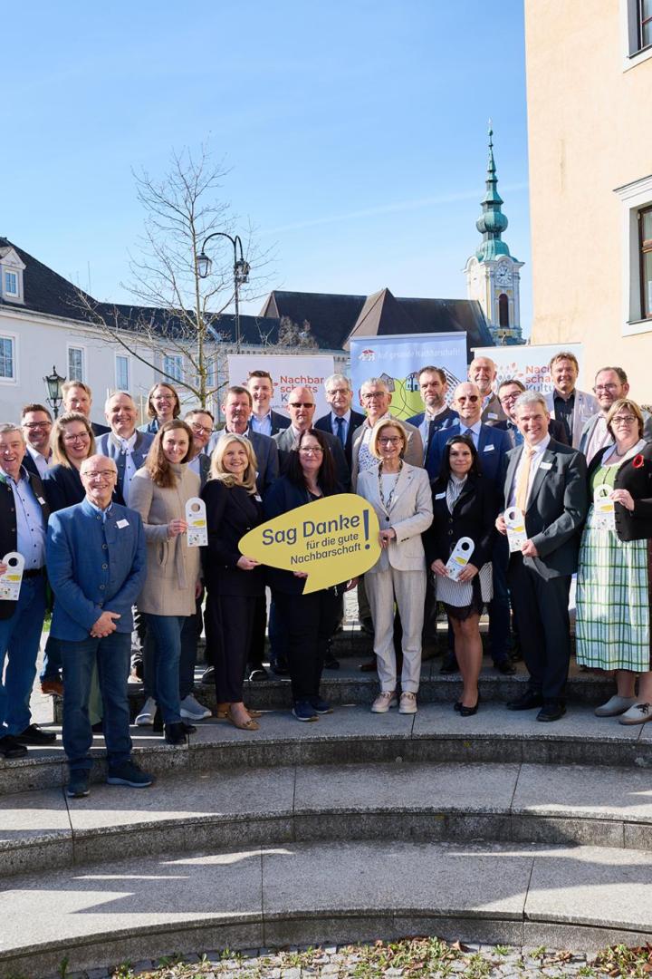 Vertreterinnen und Vertreter des Vereins „NachbarschaftsKultur Waldviertel" stehen gemeinsam mit Landeshauptfrau Mikl Leitner und Bürgermeistern der umliegenden Gemeinden vor dem Stadtsaal in Groß Siegharts.