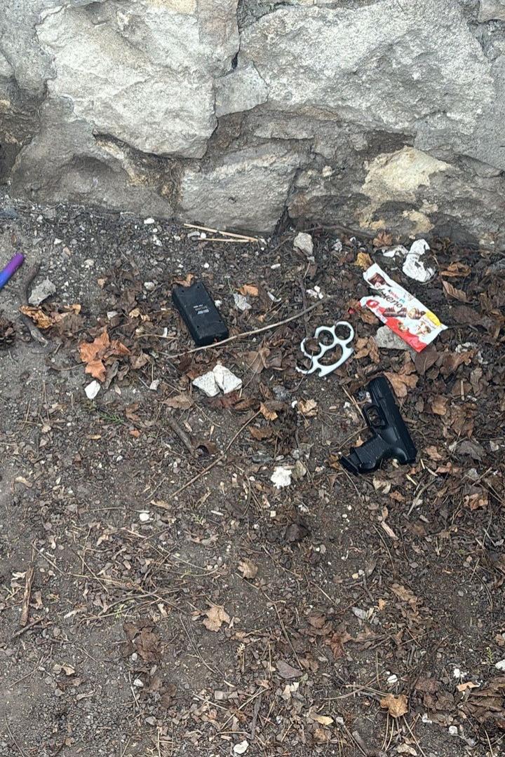 Waffen liegen auf erdigem Untergrund.