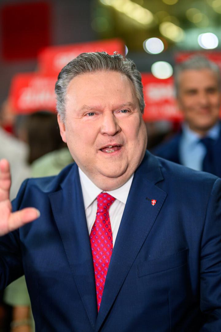 Michael Ludwig in einem blauen Anzug mit roter Krawatte winkt in einer Menschenmenge.