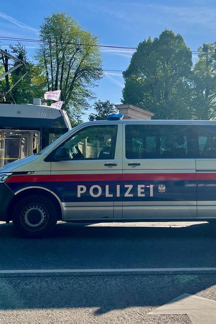 Polizeiauto, dahinter eine Straßenbahngarnitur. 
