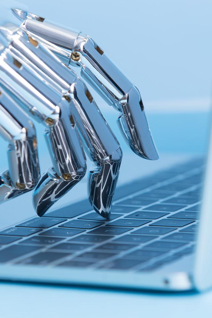 Roboterhand tippt auf einer Laptop-Tastatur.