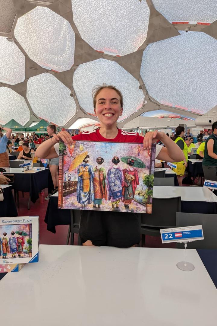 Simone Reicht, Team-Staatsmeisterin im Speed Puzzeln, hält stolz ihr fertig gestelltes Puzzle im Einzelbewerb der Weltmeisterschaft hoch