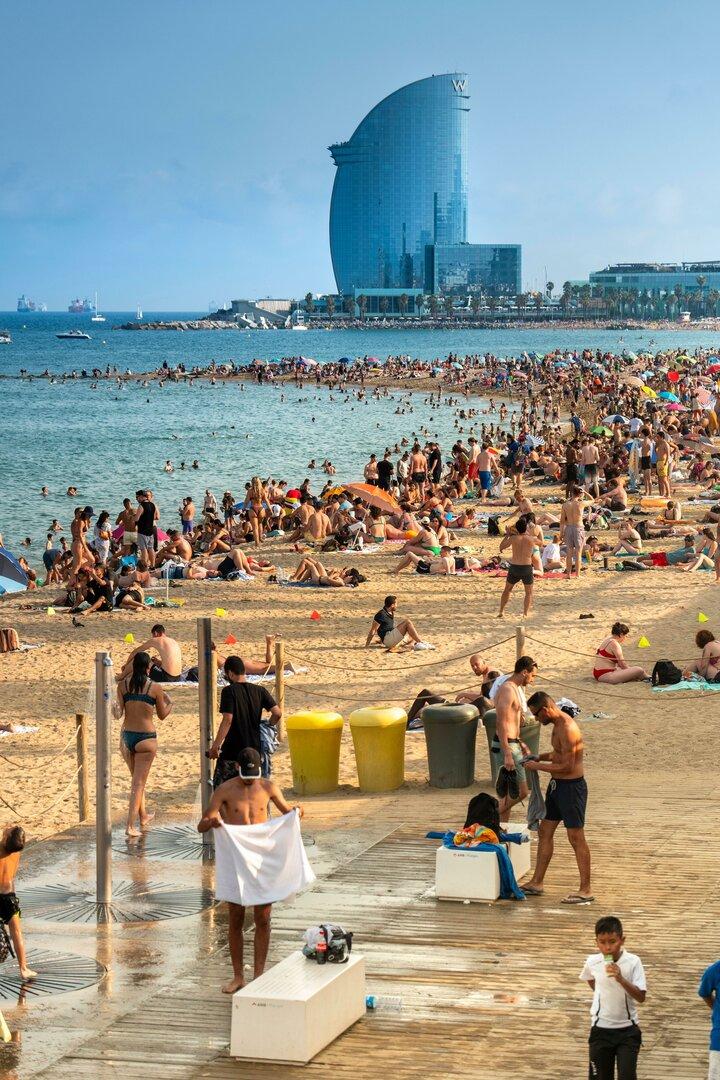 Ein Strand in Barcelona mit einem bekannten Hotel im Hintergrund