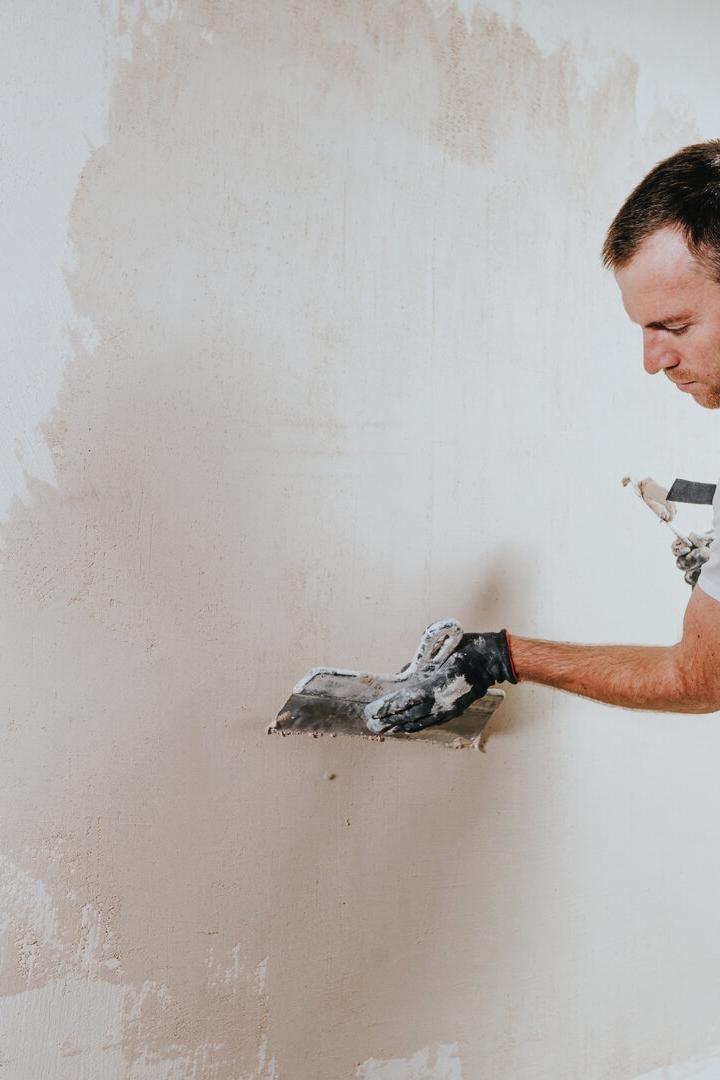 Arbeiter verputzt Wand