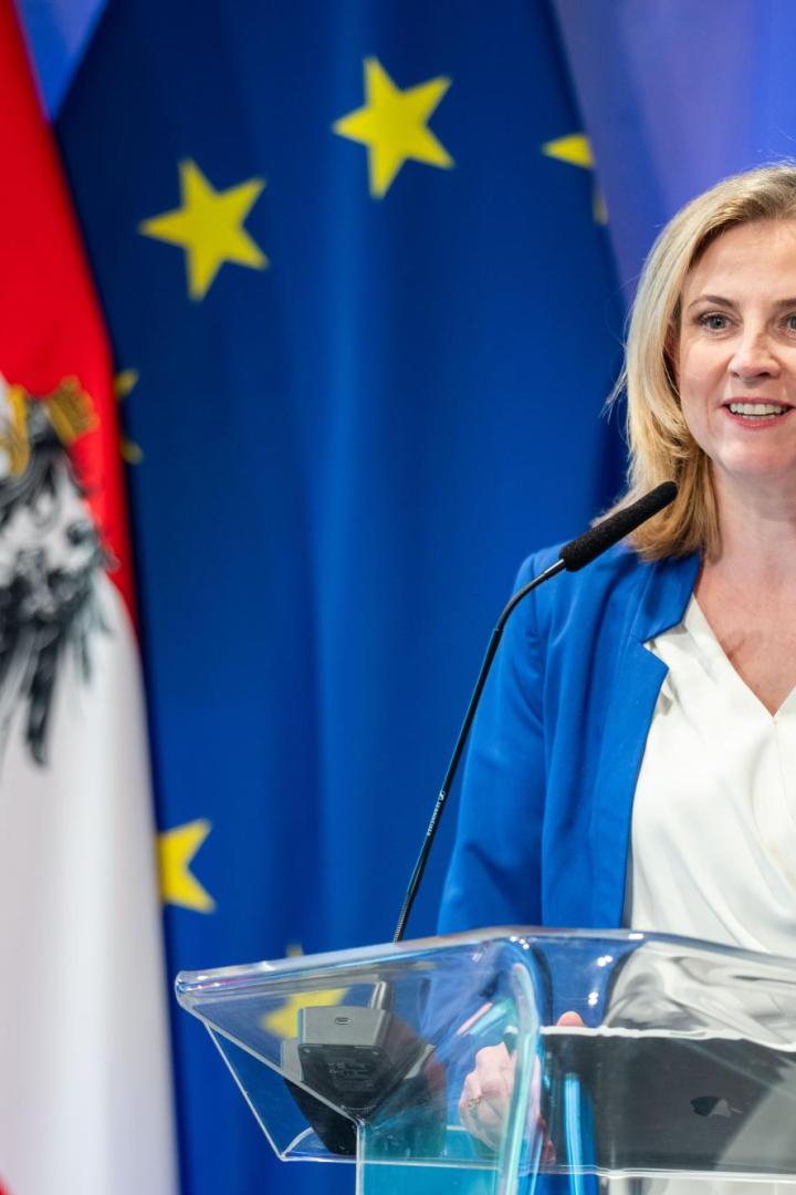 Beate Meinl-Reisinger vor einer Österreich- und einer EU-Fahne.