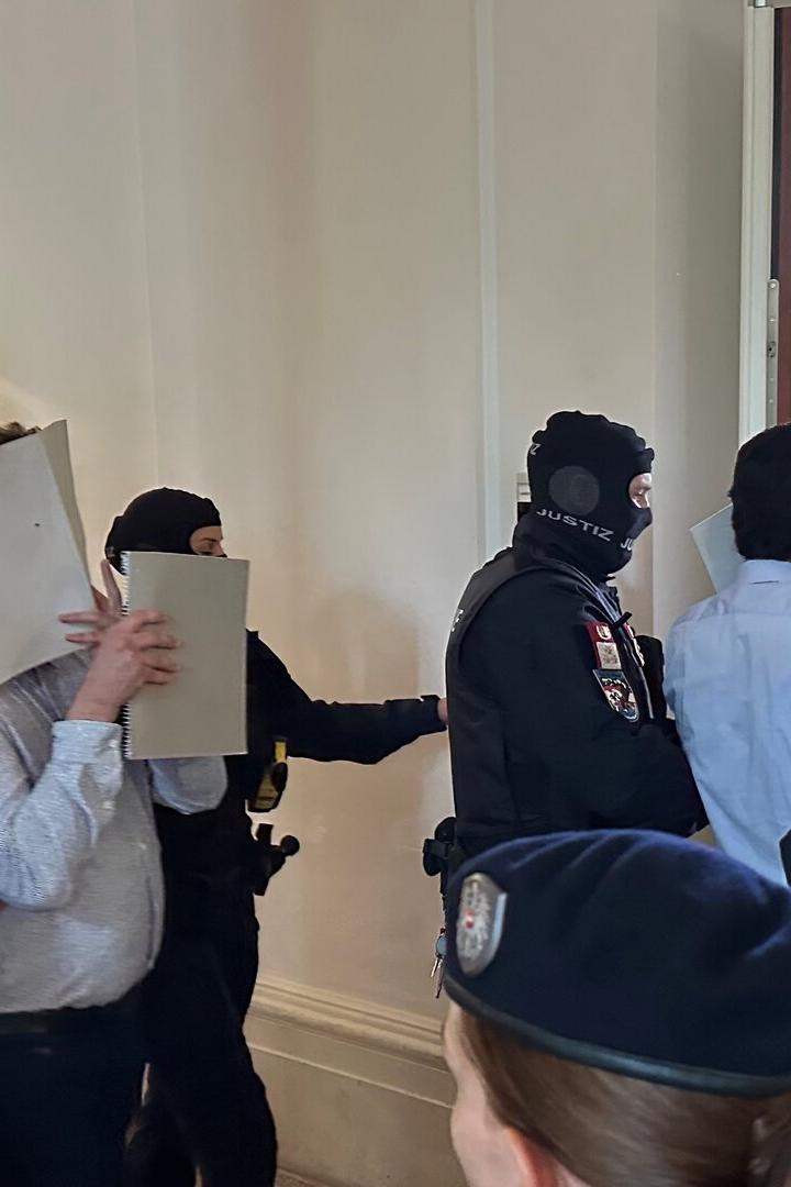 Angeklagte werden in einen Gerichtssaal geführt