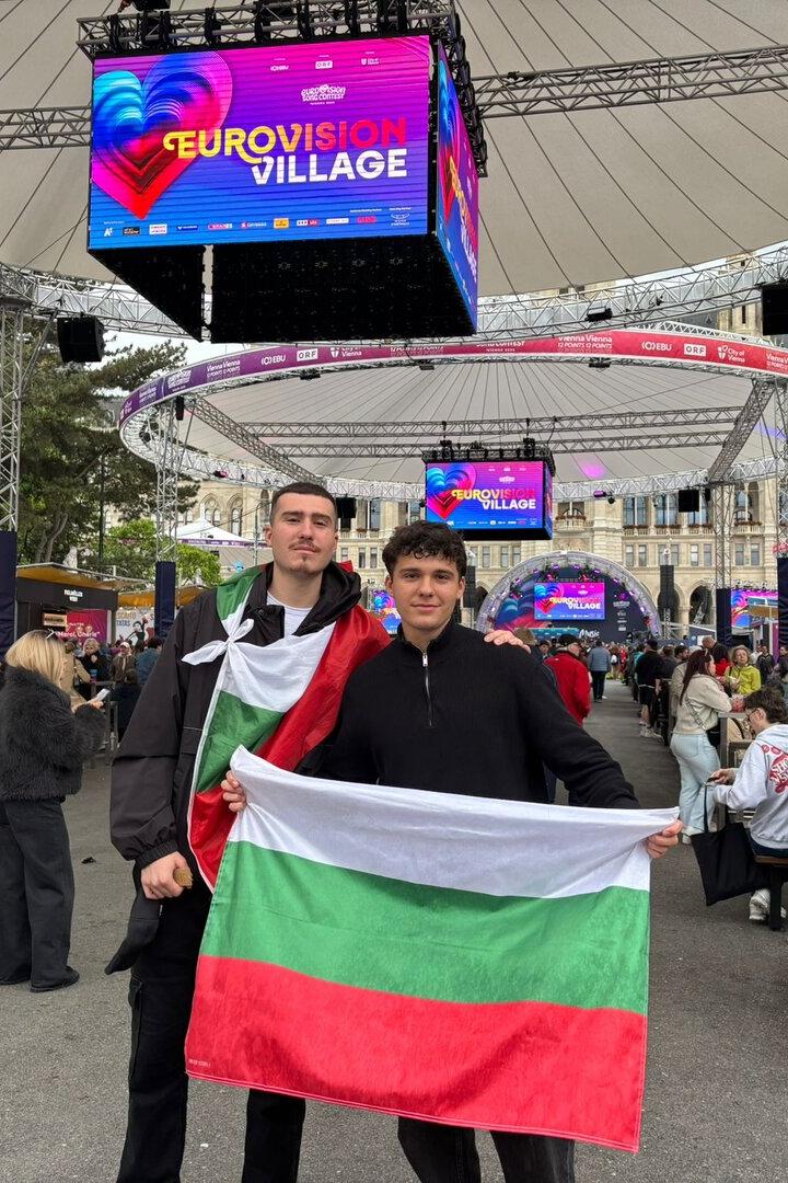 Zwei Männer halten eine bulgarische Flagge im Eurovision Village.