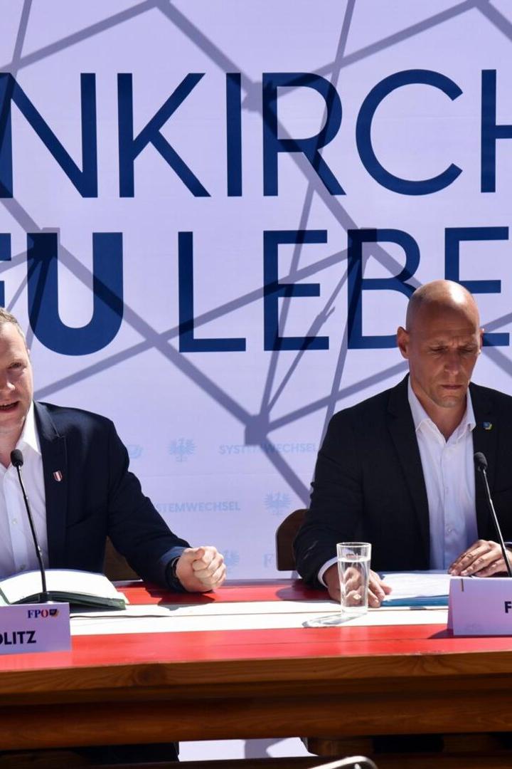 Zwei Männer vor einem Wahlplakat
