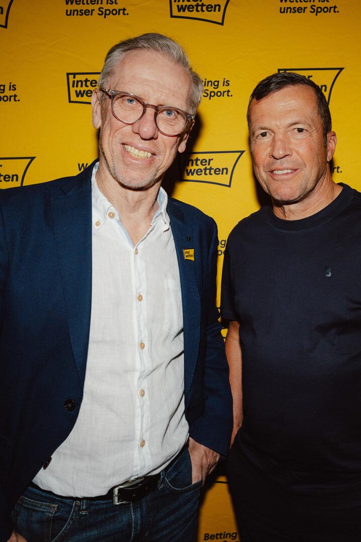 Peter Stöger und Lothar Matthäus posieren vor einer Sponsor-Wand.