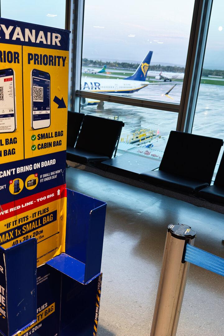 Ryanair signage at Manchester Airport waiting area with planes outside window