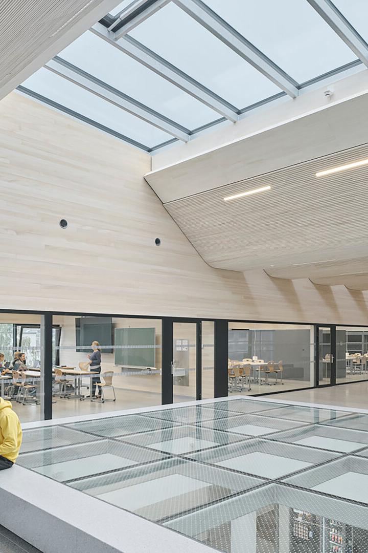 Innenaufnahme der TU Bau und Design in Innsbruck. Viel Holz und Glas zeichnen das Gebäude aus. 