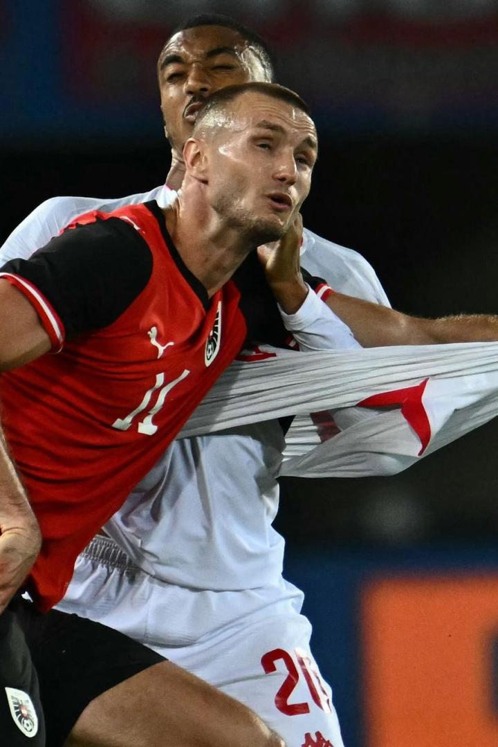 Zwei Fußballspieler kämpfen um den Ball, einer zieht am Trikot des anderen.