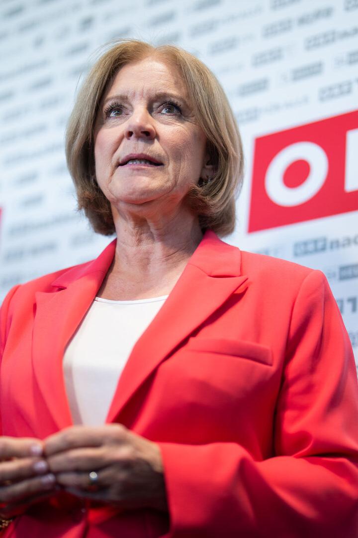 Ingrid Thurnher in einem roten Blazer spricht vor einer Pressewand mit dem Logo des ORF.