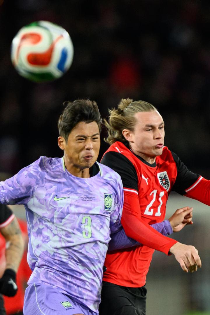 Ein Spieler aus Südkorea und ein österreichischer Nationalspieler kämpfen im Zweikampf um einen hohen Ball.