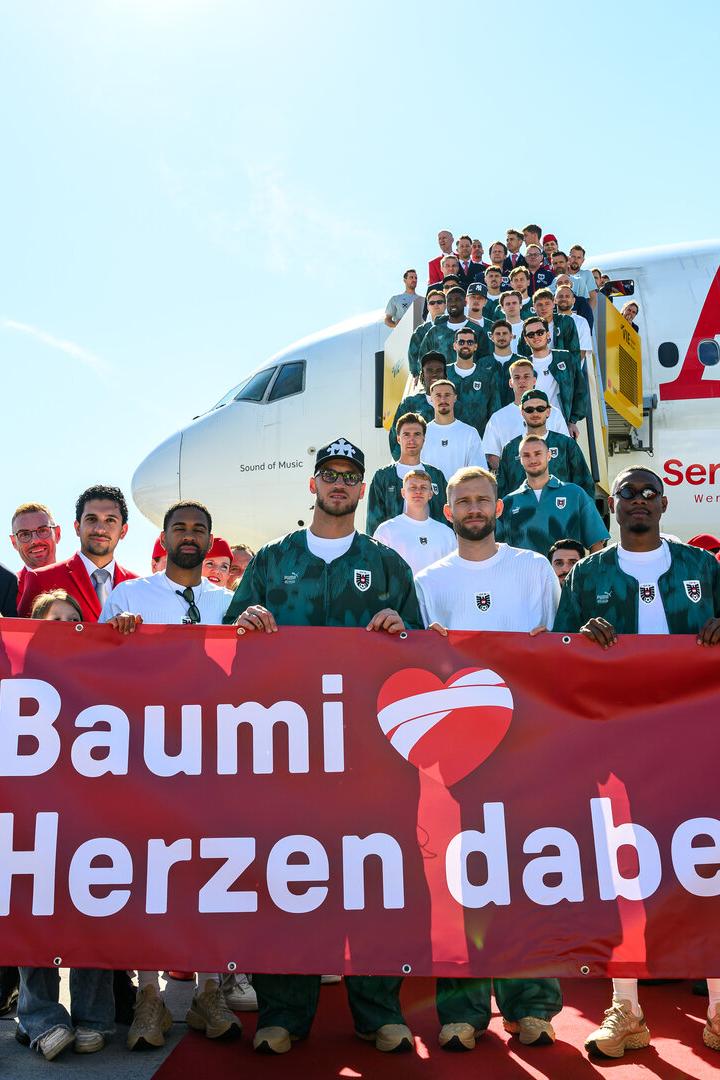Das ÖFB-Team präsentiert vor dem AUA-Flieger ein Transparent für Baumgartner.