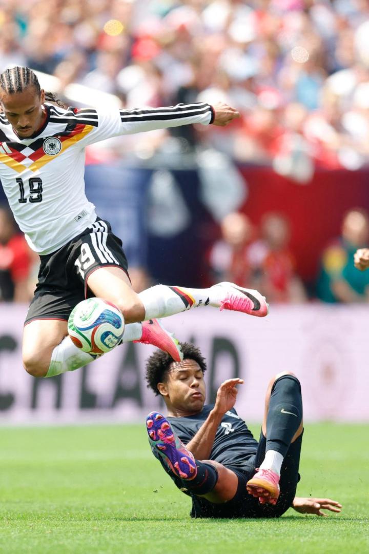 Leroy Sané im deutschen Trikot springt im Zweikampf über einen am Boden liegenden US-amerikanischen Spieler.