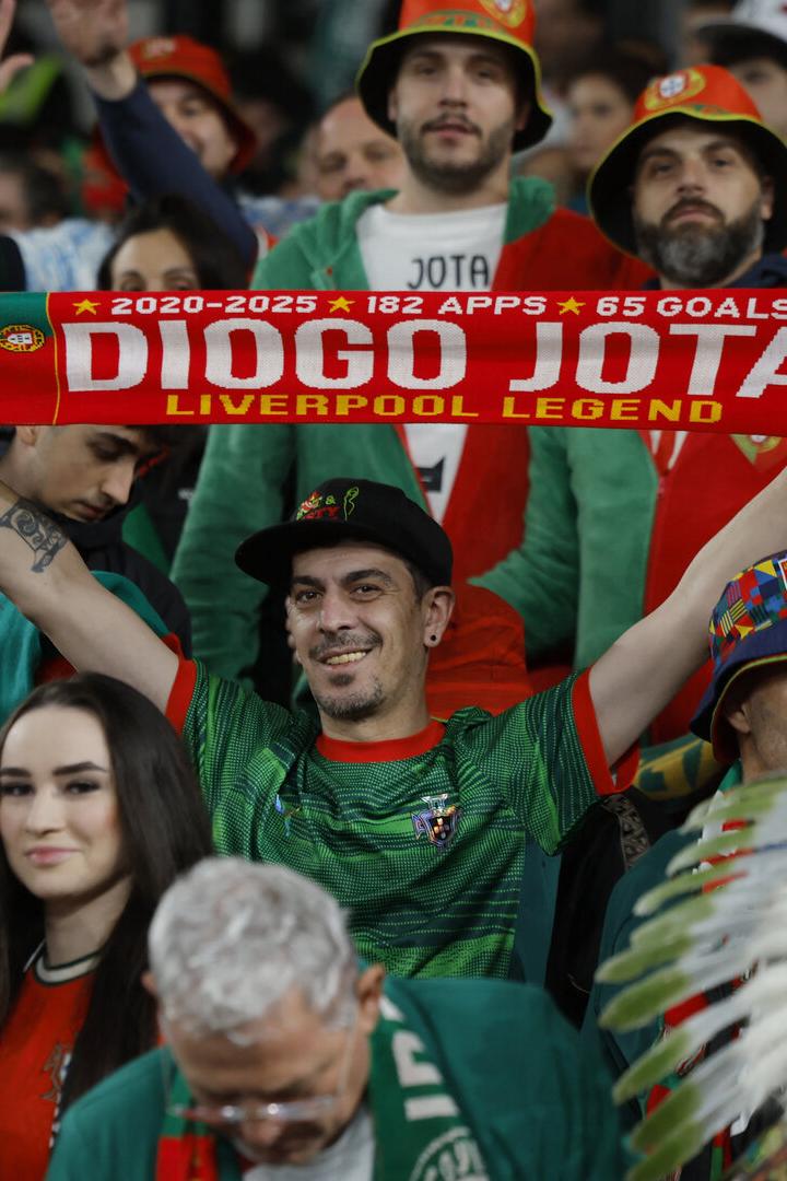 Fan hat einen roten Schal mit der Aufschrift "Diogo Jota" in der Hand