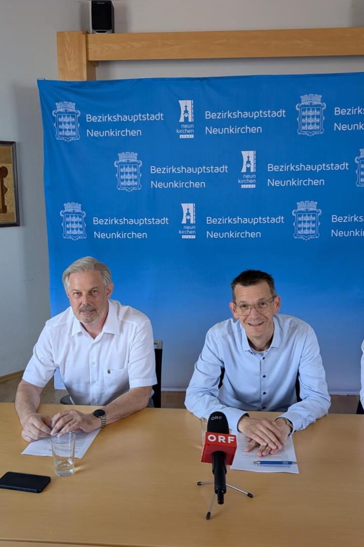 vier Männer sitzen an einem Tisch.
