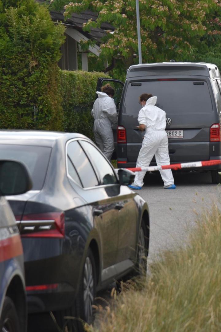 Polizei und Spurensicherung arbeiten an einem abgesperrten Wohnhaus.