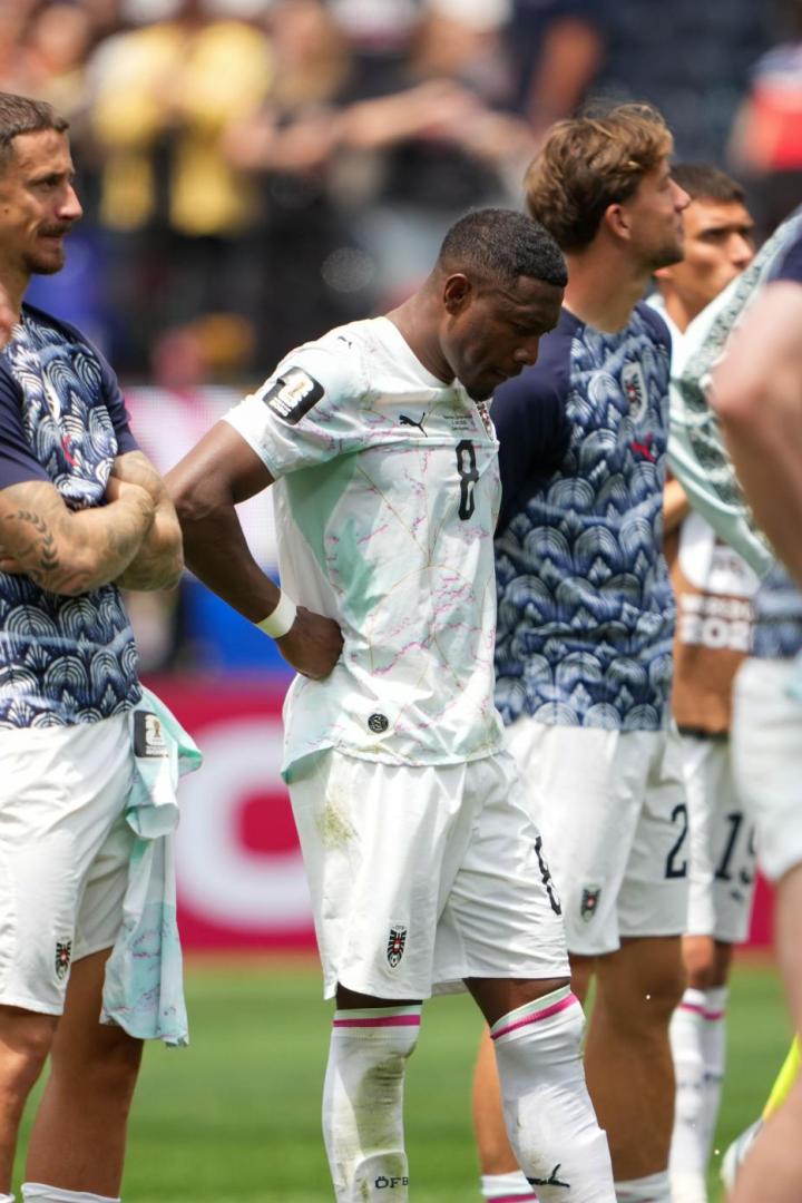 Spieler der österreichischen Fußballnationalmannschaft stehen enttäuscht auf dem Rasen.