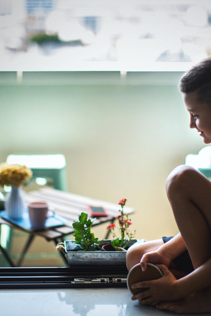 Boy Finds Joy Sitting by the Window.