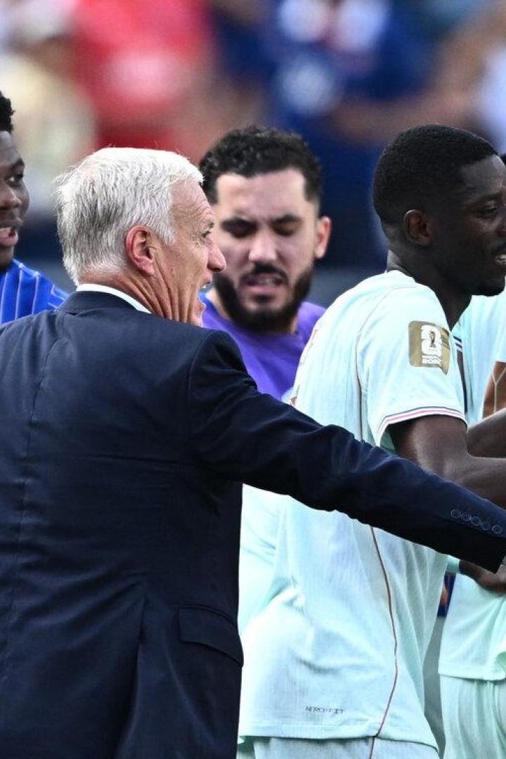 Frankreich in türkisen Trikots stehen auf dem Fußballfeld und schauen ihren Trainer an