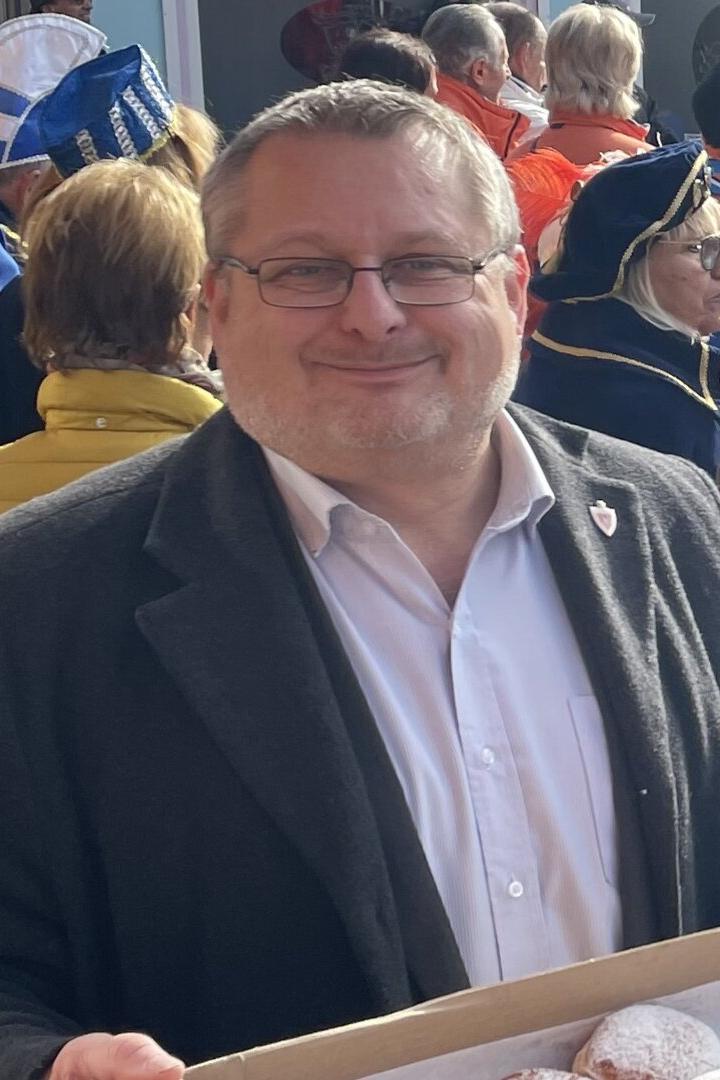 Andreas Kutheil auf einem Fest mit Krapfen in der Hand.