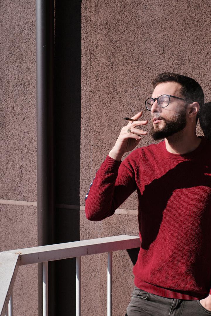 Mann raucht am Balkon
